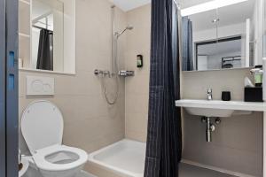 a bathroom with a toilet and a sink and a shower at RS Boardinghouse Aparthotel mit Charme und Hotelservice in St. Gallen +16 photos