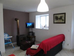 a living room with a red blanket on a couch at Gite la ruche in Senon