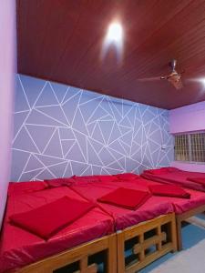 a bedroom with a red bed and a blue wall at Greenwoods Resort Dandeli in Kervād