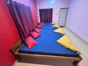 a row of beds in a room with red and yellow pillows at Greenwoods Resort Dandeli in Kervād