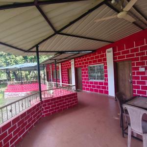 a red brick building with awning and tables and chairs at Greenwoods Resort Dandeli in Kervād