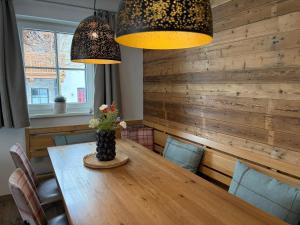 a dining room with a wooden table and two lights at Chalet in Niedernsill near Ski Slopes in Niedernsill