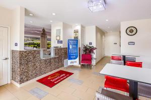 a lobby with red chairs and a counter in a building at Econo Lodge Baton Rouge University Area in Baton Rouge