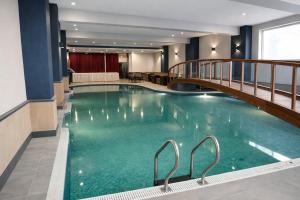 a large swimming pool with a bridge in a hotel at Hotel Diplomat Residency in Bareilly