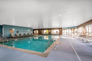 a large swimming pool with chairs in a building at Clarion Inn Elmhurst - Oak Brook near I-88, I-290, I-294 in Elmhurst