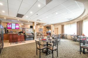 a restaurant with tables and chairs and a bar at Clarion Inn Elmhurst - Oak Brook near I-88, I-290, I-294 in Elmhurst