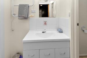 a bathroom with a white sink and a mirror at Kin Kin Retreat in Quinninup +83 photos