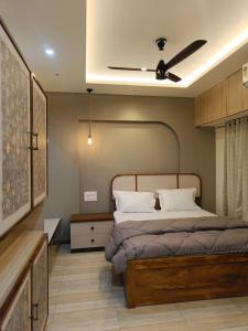 a bedroom with a bed with a ceiling fan at Desai Home Stay in Kolhapur