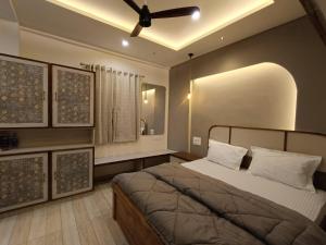 a bedroom with a bed and a ceiling fan at Desai Home Stay in Kolhapur +7 photos