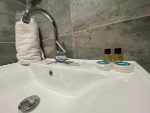 a bathroom sink with a faucet and two candles on it at Rosse Hotel in Esenyurt