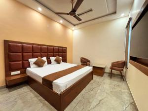 a bedroom with a large bed and a television at HOTEL AROMA CROWN in Zirakpur +9 photos