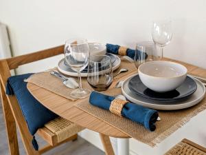 a wooden table with plates and wine glasses on it at Le Solent in Courseulles-sur-Mer