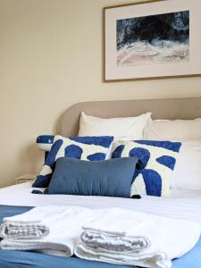 a bed with blue and white blankets and pillows at Le Solent in Courseulles-sur-Mer