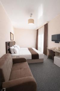 a hotel room with a bed and a couch at Hotel Green Town in Kutaisi