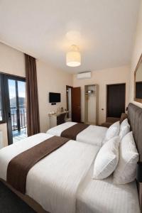 a hotel room with two beds and a television at Hotel Green Town in Kutaisi