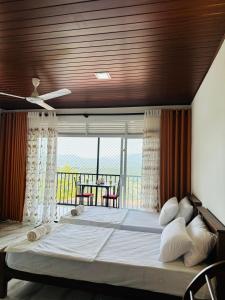 a bedroom with a large bed and a balcony at Mount Vista Homestay Kandy in Kandy