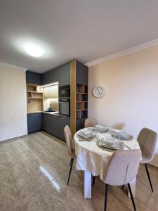 a dining room with a white table and chairs at Private Apartments Olymp in Sveti Vlas