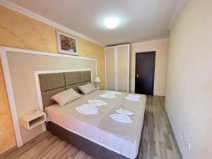 a bedroom with a large bed with towels on it at Private Apartments Olymp in Sveti Vlas