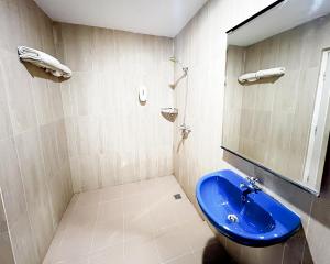 a bathroom with a blue sink and a mirror at Hotel Beverly Inn Batam Center in Batam Center +16 photos
