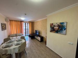 a living room with a table and a couch at Private Apartments Olymp in Sveti Vlas