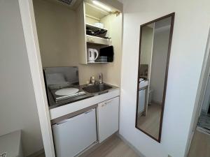 a small kitchen with a sink and a mirror at N's Hotel 平和公園 in Hiroshima +22 photos