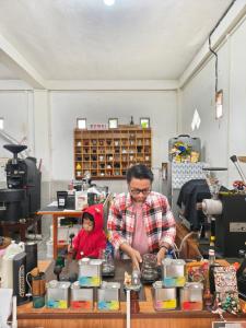 a man and a child standing in a room at Pintu Biru Hostel in Wamena