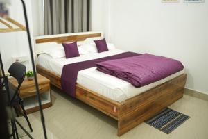 a bedroom with a bed with purple and white pillows at Shivalik stays in Jorhat