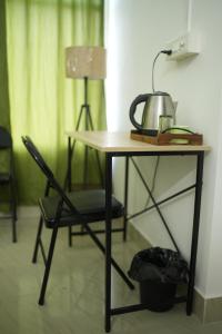 a desk with a chair and a tea kettle on it at Shivalik stays in Jorhat