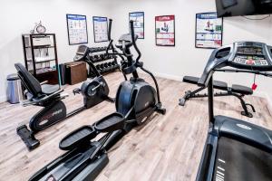 a gym with three exercise bikes in a room at Aggie Inn, an Ascend Collection Hotel in Davis