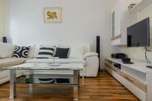 a living room with a couch and a tv at Apartment Era in Trogir