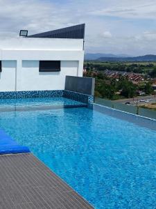 a swimming pool in front of a white house at I&M Staycation in Alor Setar