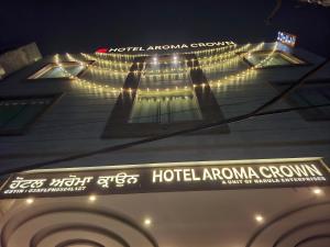 a building with a hotel astronomy sign on it at night at HOTEL AROMA CROWN in Zirakpur