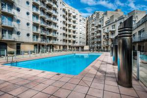 a swimming pool in front of some apartment buildings at Studio Zeezicht in Ostend