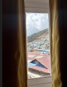 a view of a city from a window at Highcamp B&B in Namche