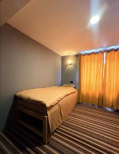 a bedroom with a bed and a large window at Highcamp B&B in Namche