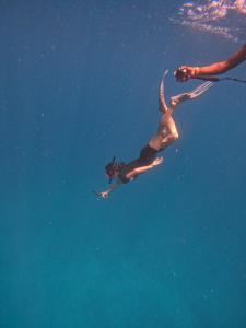 a man is swimming in the water at Karanka Villa @ Mahibadhoo in Mahibadhoo