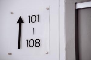 a clock on a wall with an arrow on it at The Marion Hotel Impian Emas Branch in Skudai