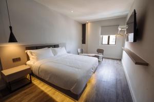 a bedroom with a large white bed and a desk at The Marion Hotel Impian Emas Branch in Skudai +11 photos