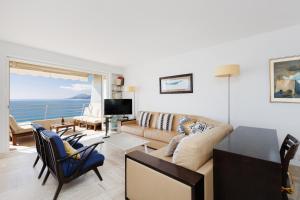 a living room with a couch and a tv at Mer du Sud 4 YourHostHelper in Cannes