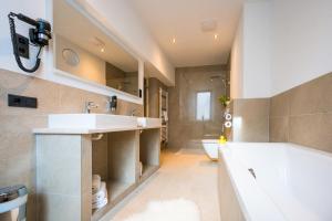 a bathroom with a sink and a tub and a toilet at Hotel Wilder Mann in Steinach am Brenner