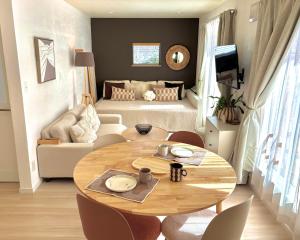 a living room with a table and a couch at Lalafofofo in Biei