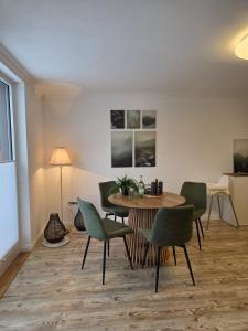 a dining room with a table and green chairs at Blick zur Burg in Nörten-Hardenberg