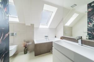 a bathroom with a sink and a bath tub and a window at Apartmán VALORI - 100m2 in Poděbrady +29 photos