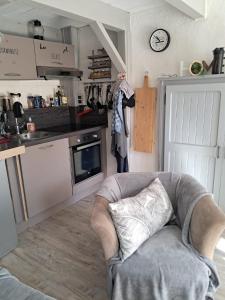 a living room with a chair and a kitchen at La Modestine in Lanuéjols