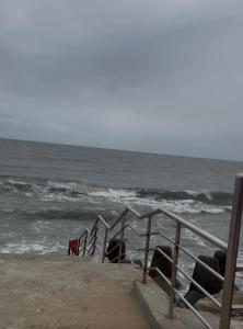 a stairway to the beach with the ocean at Jacobs Cottage KG-F1 in Thiruchendur +4 photos