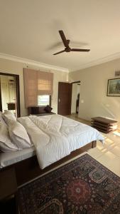a bedroom with a large bed with a ceiling fan at Silver Oak Mansion in Jalandhar +7 photos