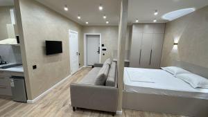 a bedroom with a bed and a couch and a kitchen at Мегаполис in Astana
