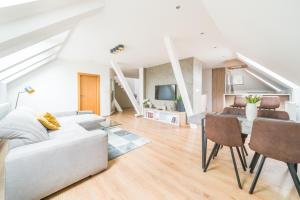 a living room with a white couch and a table at Apartmán VALORI - 100m2 in Poděbrady