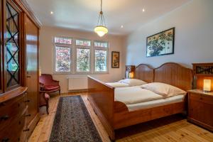 a bedroom with a wooden bed and a dresser and windows at Romantisches Hotel zur Post in Brodenbach