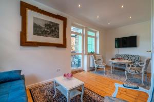 a living room with a blue couch and a table at Romantisches Hotel zur Post in Brodenbach